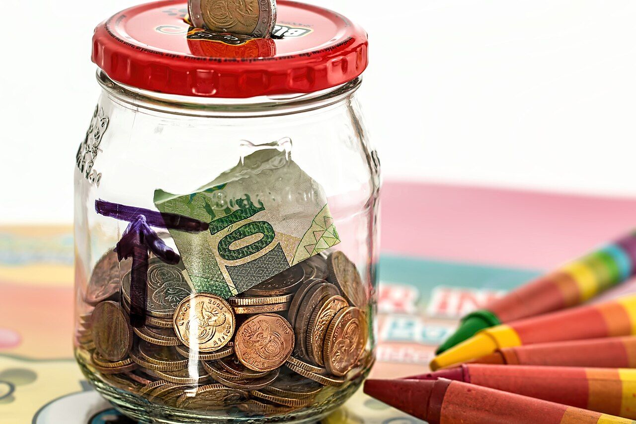 A small pink piggy bank on a plain surface, representing an emergency fund.